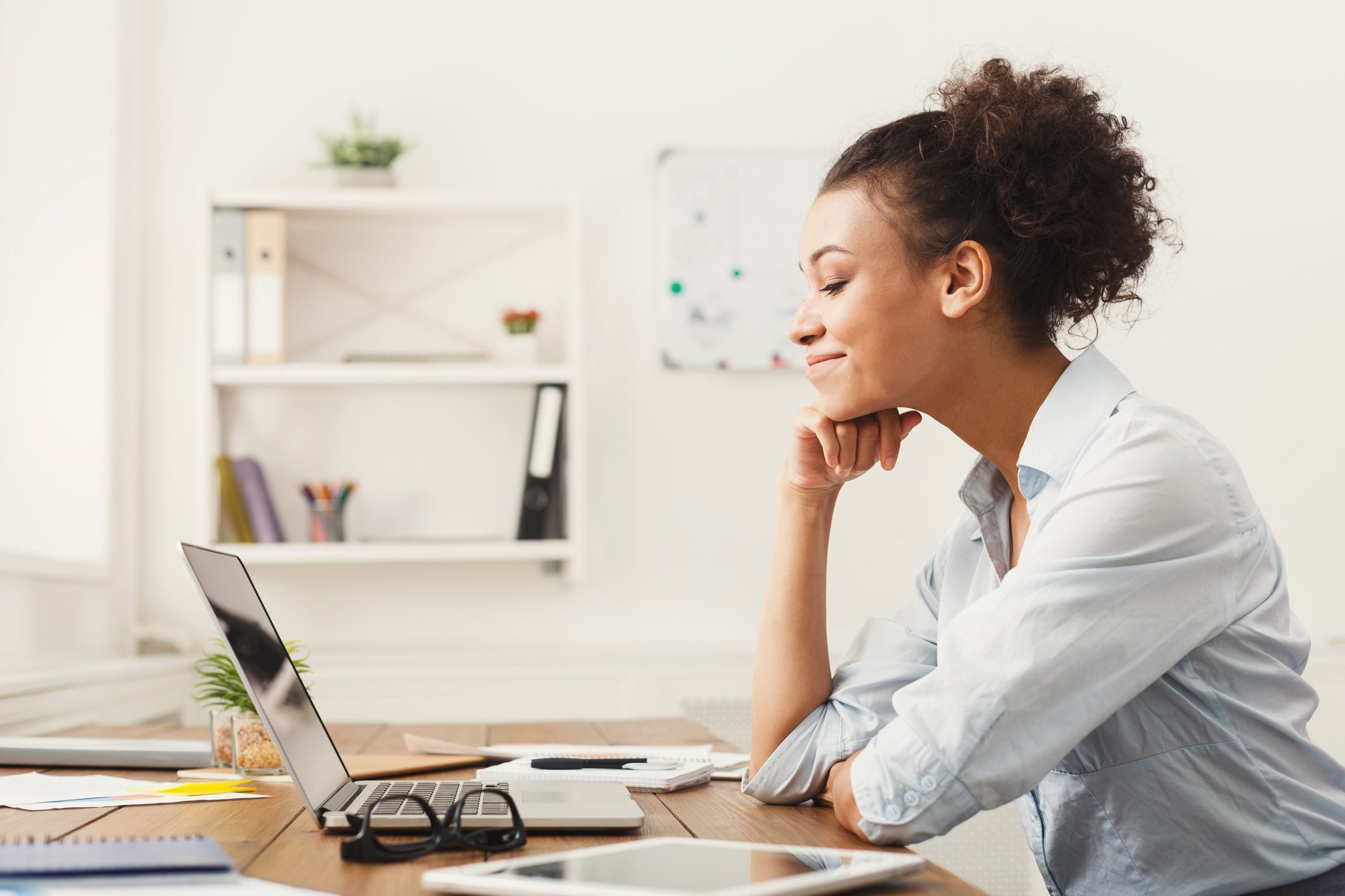 Happy business woman working on laptop at office