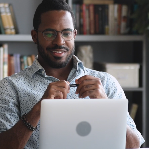 A man looking at his laptop smiling.