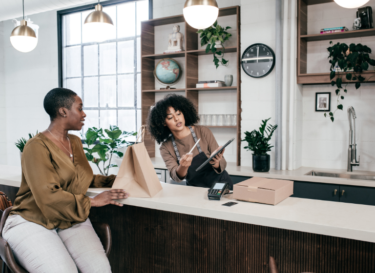 women talking over counter with tablet