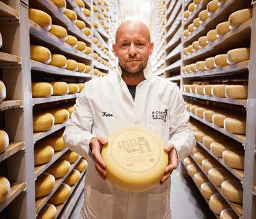 man standing in cheese wheel aisle